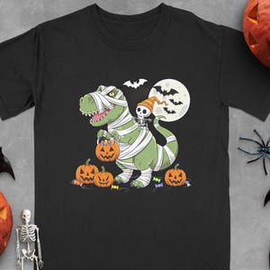 Halloween Dinosaur Mummy T-Shirt, Cute T-Rex in Bandages, Mummy Dinosaur with Pumpkins, Spooky Halloween Shirt for Kids, Dinosaur Lovers Tee
