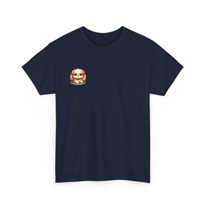 May include: Navy blue t-shirt featuring a small, embroidered illustration of a cute, cartoon-style Shih Tzu puppy sitting down. The puppy is light brown and tan, with dark eyes. The image is centered on the left chest area of the shirt. The shirt is a classic crew neck style, short-sleeved, and appears to be made of a soft, comfortable fabric.