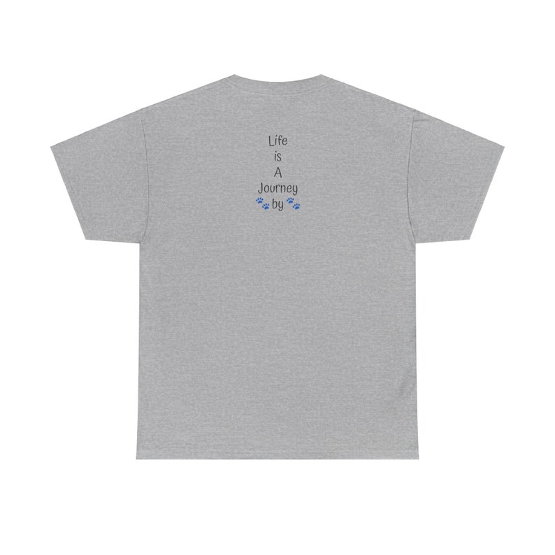 May include: Back view of a heather gray unisex t-shirt featuring a vertical text design. The text reads: 'Life is A Journey by' with small paw prints in blue between 'Journey' and 'by'. The shirt is a relaxed fit, short-sleeved tee.