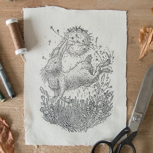 Könnte beinhalten: Eine Schwarzweißillustration eines Kaninchens, das durch ein Feld mit Blumen springt. Das Kaninchen ist in einem detaillierten, realistischen Stil gezeichnet, und die Blumen sind stilisiert.