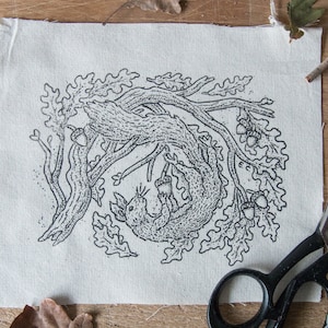 May include: Black and white illustration of a squirrel climbing an oak tree branch with acorns. The illustration is printed on a white canvas fabric.
