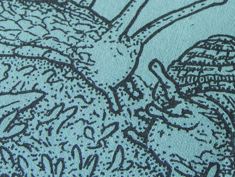 May include: A light teal fabric featuring a detailed black ink illustration of a snail with a textured shell and a long neck. The design includes intricate line work and stippling patterns that create depth and shadow across the surface of the material.