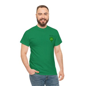May include: A green t-shirt with a small green four-leaf clover graphic on the left chest. The clover has a face and says "Luck of the Irish I believe in me".