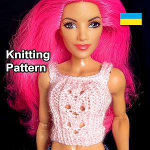 May include: Knitting pattern for a pink crocheted top with a lace design. The pattern is for a doll.