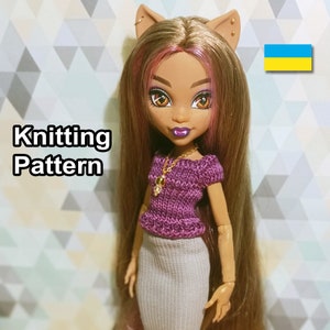 May include: Knitting pattern for a purple and grey doll outfit. The doll has brown hair and brown eyes. The outfit includes a purple knitted top with short sleeves and a grey knitted skirt. The doll is wearing a gold necklace with a charm.