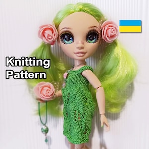 Puede incluir: Patrón de tejido para un vestido verde con diseño de hojas. El vestido lo lleva una muñeca con el pelo verde y flores rosas en el pelo. La muñeca lleva una flor rosa.