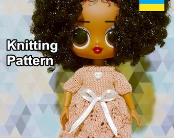 May include: Knitting pattern for a pink dress with white lace detailing and a white bow. The dress is being worn by a doll with large eyes and black curly hair. The doll is wearing a pink headband. The image also includes the Ukrainian flag.