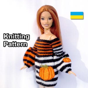 Puede incluir: Patrón de tejido para un vestido de muñeca con rayas negras, blancas y naranjas y detalles de calabaza. El vestido tiene un escote ligeramente caído y mangas largas. La muñeca lleva el vestido y tiene el pelo largo y rojo.