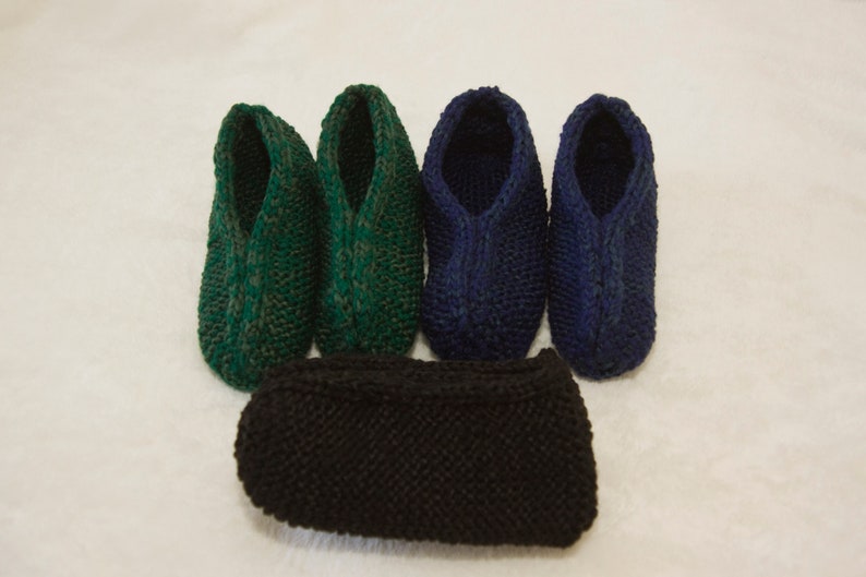 May include: Four pairs of knitted slippers in green and blue colors. One pair of black knitted slippers is in the center of the image.