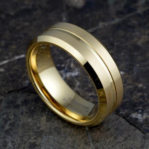 Gold tungsten carbide 8mm ring angled showing contrast between brushed matte exterior and polished groove detail, TUNGSTEN CARBIDE stamped inside