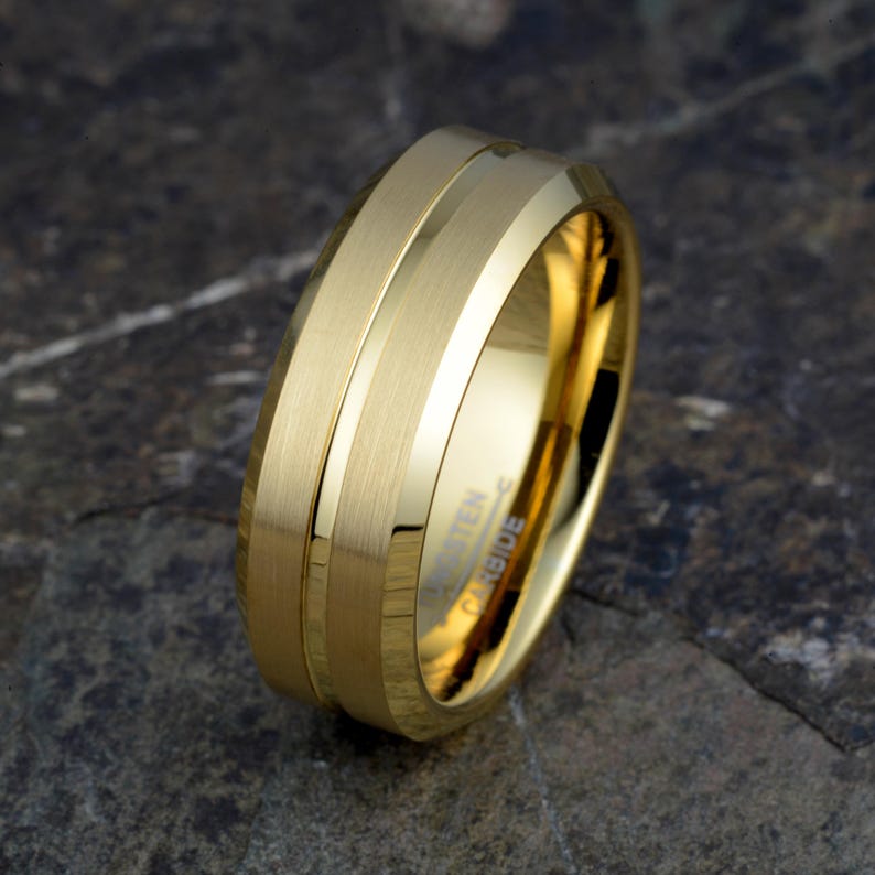 Gold tungsten 8mm ring tilted displaying brushed bands separated by polished groove accent and TUNGSTEN CARBIDE interior engraving, mens wedding band on stone