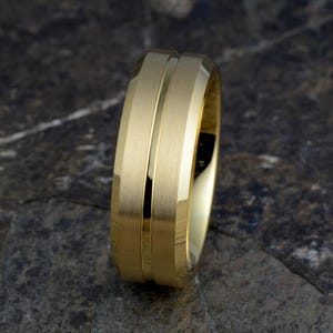 Side view gold tungsten 8mm mens ring angled showing beveled edges, brushed bands with polished groove detail, TUNGSTEN CARBIDE engraved interior