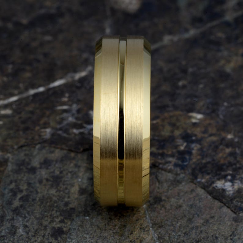 Top view gold tungsten 8mm ring standing upright showing brushed matte finish with thin polished groove running vertically, mens band on concrete