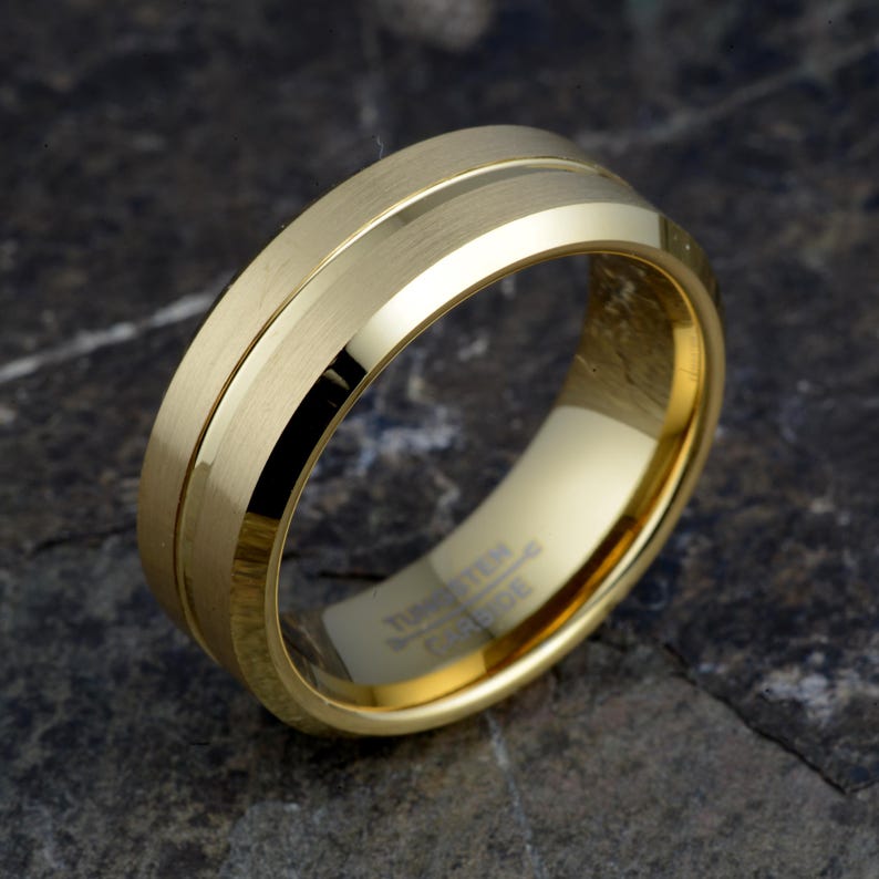 Gold tungsten carbide 8mm ring angled showing brushed matte bands with polished offset groove, TUNGSTEN CARBIDE engraved interior, mens wedding band
