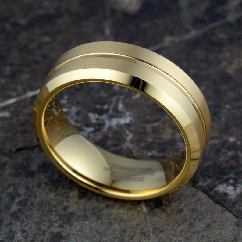 Gold tungsten carbide 8mm ring flat showing full TUNGSTEN CARBIDE engraved interior and brushed exterior with offset polished groove, horizontal view