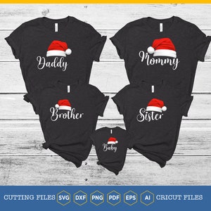 Könnte beinhalten: Fünf schwarze T-Shirts mit weißem Text und einer roten Weihnachtsmannmütze. Die Shirts sagen "Papa", "Mama", "Bruder", "Schwester" und "Baby".