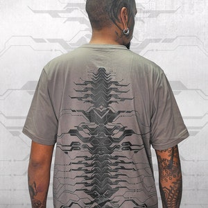 Puede incluir: Una camiseta gris con un diseño gráfico en blanco y negro de un circuito impreso en la espalda.