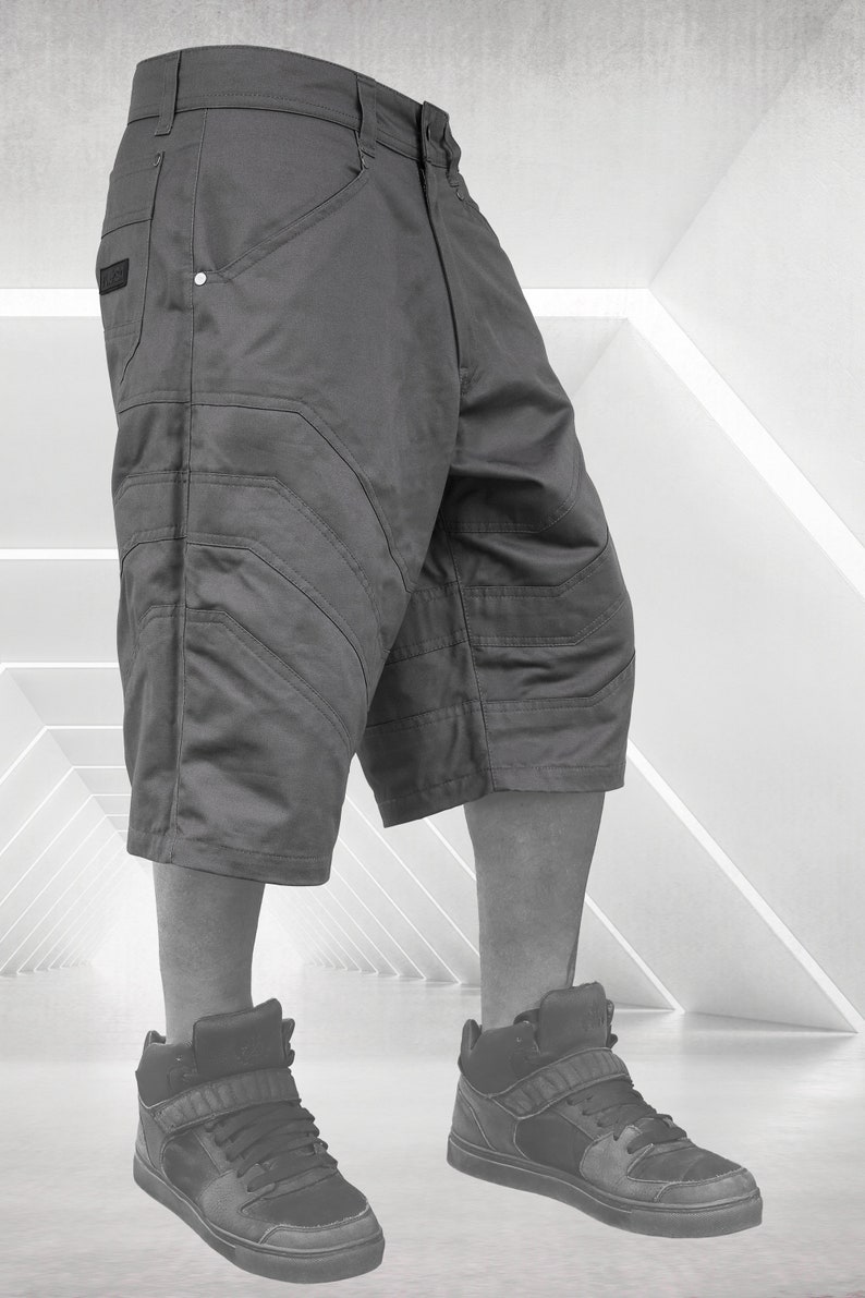 May include: Gray cargo shorts with multiple pockets and stitched detailing. The shorts are paired with black high-top sneakers. The image is set against a bright, geometric background, showcasing urban streetwear.