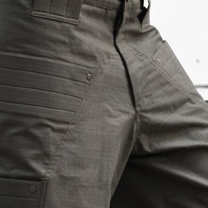 May include: A pair of dark green cargo pants with multiple pockets and a button fly.