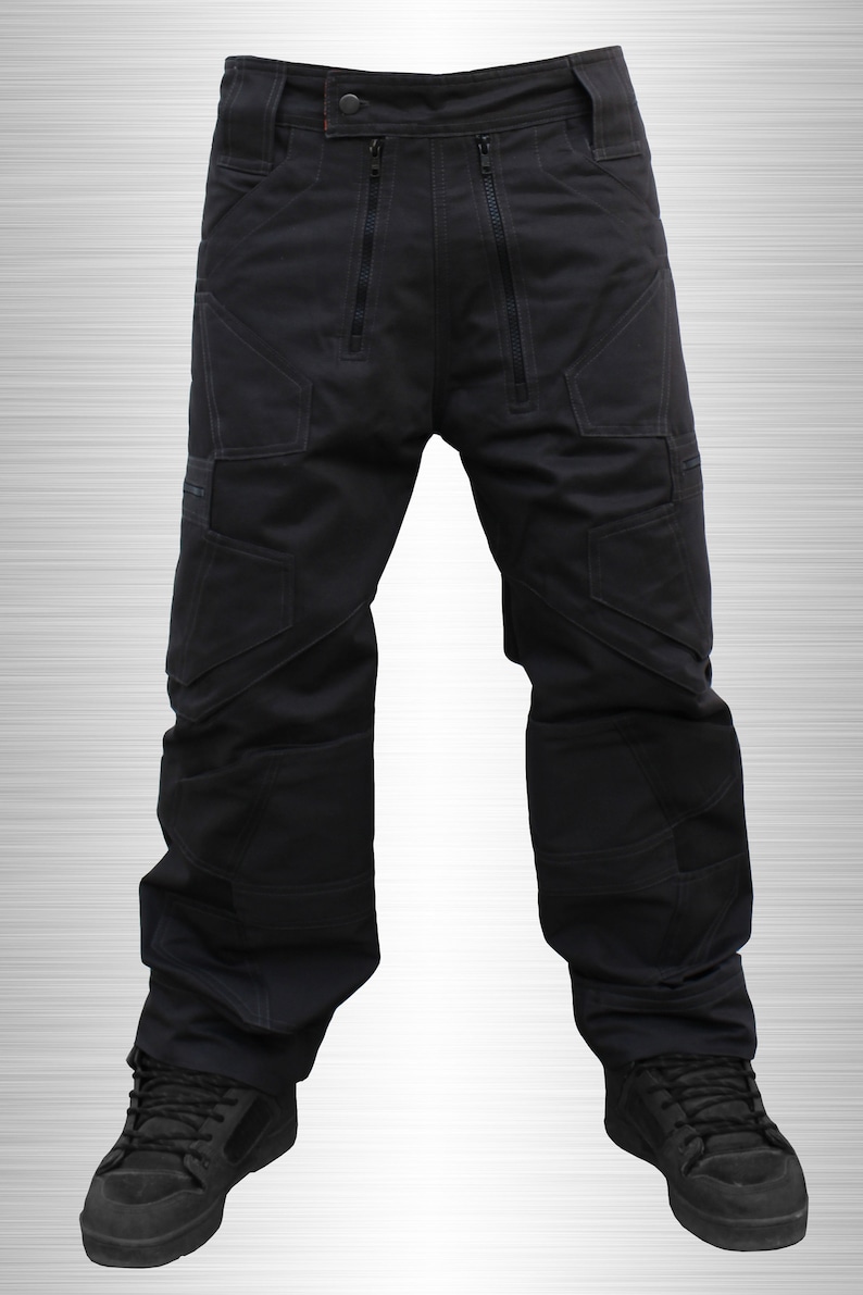 May include: Black cargo trousers with multiple pockets and zipper details. The trousers are worn with black trainers.