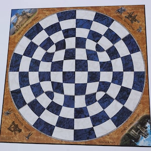 May include: A blue and white circular chess board with a unique design. The board is surrounded by a brown border with images of castles and text that reads "Castle Challenge Chess" and "Castle Attack Chess".
