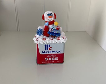 Polymer Clay Snowman sitting on a Vintage Metal Spice Tin with a Christmas Tree