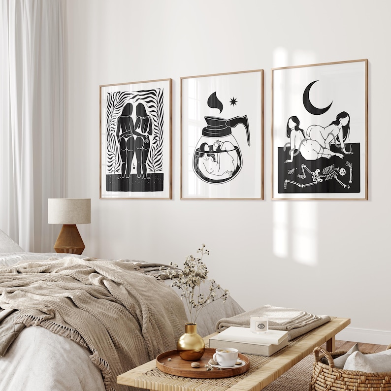 May include: Three black and white illustrations in frames on a white wall. The first illustration shows two figures standing back to back. The second illustration shows a coffee pot with a figure inside. The third illustration shows two figures lying down with a skeleton in the foreground.