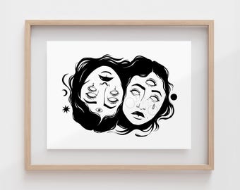 May include: A black and white line art print in a light wood frame featuring two faces joined together. One face is inverted with multiple eyes, while the other has a third eye on the forehead and a teardrop mark. Celestial symbols like a star, crescent moon, and circle surround the figures.