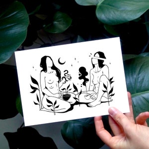Puede incluir: Ilustraci&oacute;n en blanco y negro de dos figuras sentadas en un jard&iacute;n. Las figuras est&aacute;n desnudas y tienen el pelo recogido hacia atr&aacute;s. Cada una sostiene una taza y parecen disfrutar de un momento de paz y tranquilidad.
