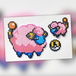 May include: A pink and blue Pokemon character made of perler beads. The character is a sheep with a blue face and a yellow ear. There is a smaller pink and blue Pokemon character next to it, and a grey and yellow Pokeball.