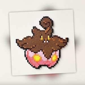 May include: A brown and pink pixel art character with a brown head and a pink body. The character has a round head with a small mouth and two yellow eyes. The character is wearing a pink skirt with yellow dots.