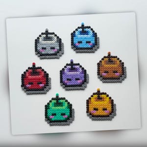 May include: A collection of seven pixel art figures in various colors, including gray, blue, red, purple, brown, green, and yellow. Each figure has a similar design with a rounded shape, black outlines, and small details.