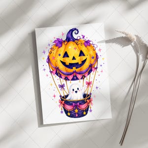 Puede incluir: Ilustraci&oacute;n en acuarela de un globo aerost&aacute;tico con tem&aacute;tica de Halloween. El globo es una calabaza sonriente con detalles morados. Un fantasma lindo saluda desde la cesta, decorada con lazos y estrellas rosas.