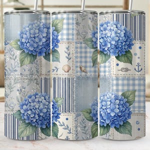 Puede incluir: Tres vasos de acero inoxidable con un diseño de patchwork con flores de hortensia azules, conchas marinas y elementos náuticos. El diseño incorpora cuadros de vichy azules y blancos, rayas y estampados florales. Cada vaso tiene una tapa plateada y una pajita.