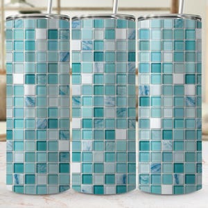 May include: Three stainless steel tumblers with a mosaic tile design in shades of blue, teal, and white. Each tumbler has a silver lid and a straw. The design is made up of small, square tiles.
