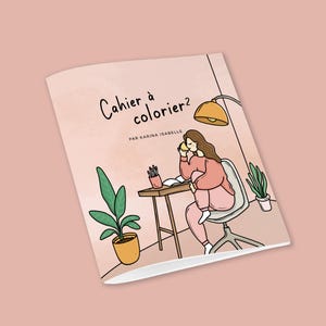 May include: A pink and white colouring book cover with the title "Cahier à colorier?" and the text "Par Karina Isabelle". The cover features a cartoon illustration of a person sitting at a desk with a cup of coffee, a lamp, and a plant.