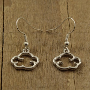 May include: A pair of silver cloud-shaped dangle earrings with a simple design.