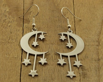 May include: A pair of silver earrings shaped like a crescent moon with dangling stars.