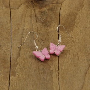May include: A pair of silver butterfly earrings with pink butterfly charms.