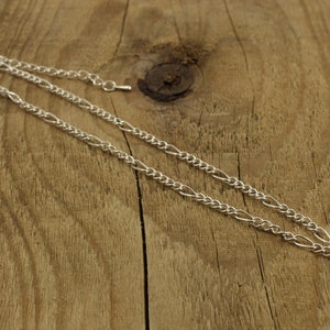 May include: A silver chain necklace with a small heart pendant.