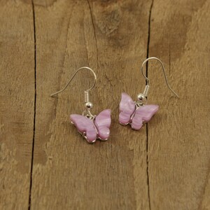 May include: A pair of silver butterfly earrings with pink and white iridescent wings.