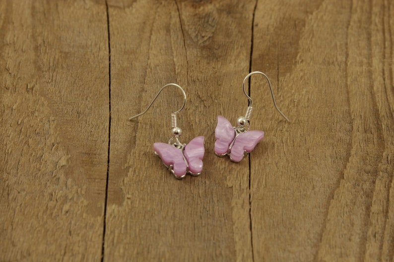 May include: A pair of silver butterfly earrings with pink and white iridescent wings.