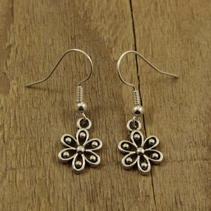 May include: A pair of silver-coloured flower earrings. Each earring has a small, six-petal flower charm with a small bead in the centre of each petal. The earrings have a simple hook design for pierced ears.