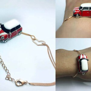 Puede incluir: Un brazalete de cadena dorada con un dije de mini coche rojo y blanco. El dije est&aacute; unido a una cadena doble con un conector en forma de coraz&oacute;n.