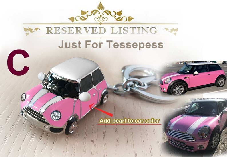 May include: A pink and white miniature car keyring with a silver key ring. The car features a white roof and white racing stripes. The image also includes a larger photo of the car.