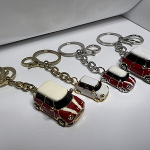 Puede incluir: Cuatro llaveros con coches Mini Cooper en miniatura de color rojo y blanco. Cada llavero tiene un estilo de cadena y anillo de metal diferente.