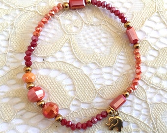 Elastic bracelet tones red, orange, gold, crystal beads, golden elephant charm