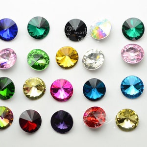 Könnte beinhalten: Sortiment runder, facettierter Glas-Straßsteine in verschiedenen Farben, darunter rosa, grün, blau, rot, gold und klar.