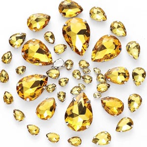 May include: Assortment of gold teardrop-shaped rhinestones of various sizes.