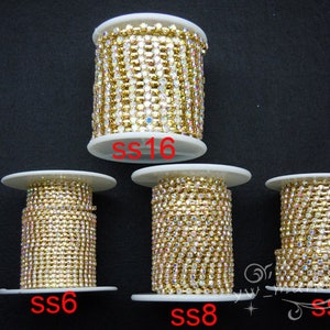 Könnte beinhalten: Vier Spulen mit goldener Strasskette, beschriftet mit SS6, SS8, SS10 und SS16. Die Kette besteht aus kleinen, klaren Strasssteinen.
